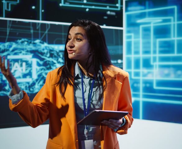 Public speaker doing presentation at tech forum event, explore ways emerging AI technologies can positively enhance companies workforce. Indian woman promoting artificial intelligence solutions